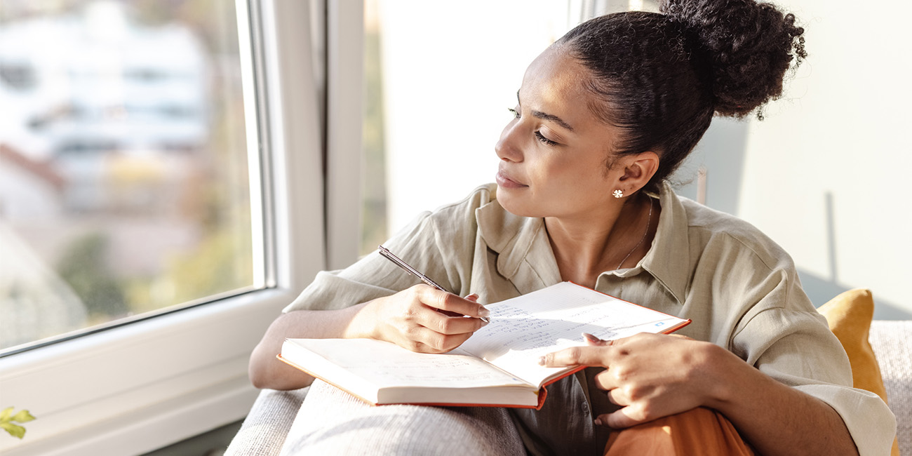 Woman journaling on her couch