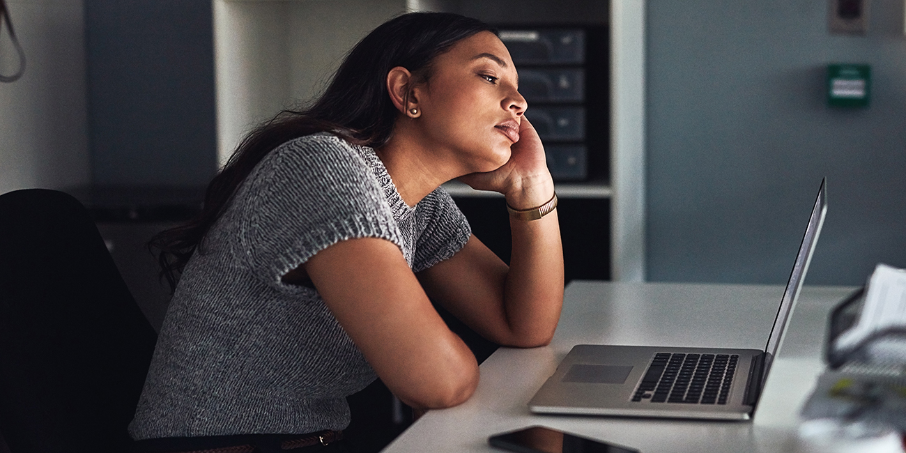 Woman sitting at a computer showing low motivation