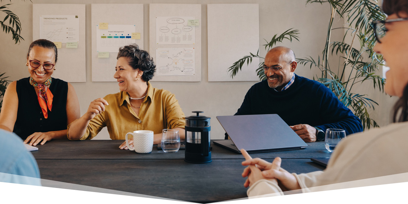 Employees sitting around a conference table laughing